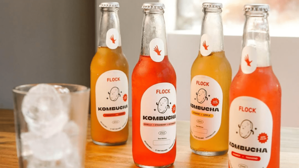 4 kombucha drinks and 1 glass with ice